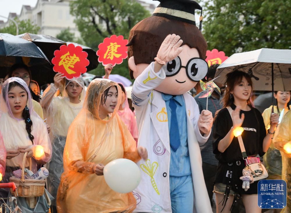 6月21日,维多利亚老品牌vic3308学生在校园里冒雨巡游。2